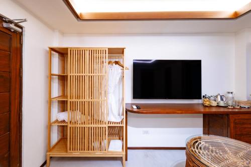 a living room with a tv and a book shelf at Morgan Villas in El Nido