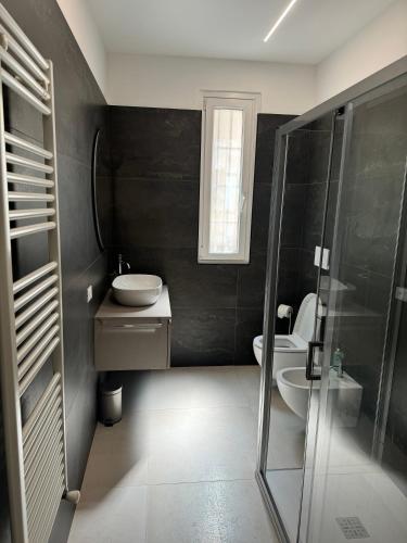 uma casa de banho com um chuveiro, um lavatório e um WC. em Appartamento Umberto em Piacenza
