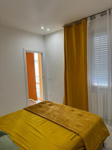 um quarto com uma cama amarela e uma janela em Appartamento Umberto em Piacenza