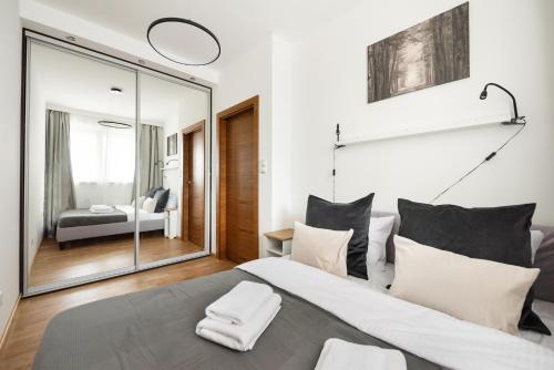 a bedroom with a large bed and a mirror at Pokorna Comfort Apartment in Warsaw