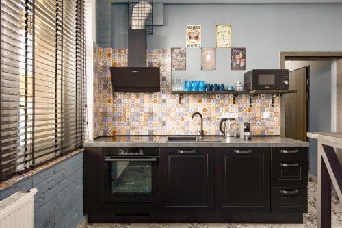 a kitchen with a sink and a stove at Karlovy Charme Inn by Rentez in Karlovy Vary