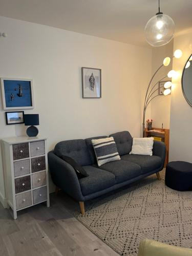 a living room with a blue couch and a dresser at THE ANCHOR in Hastings