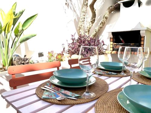 una mesa con platos y copas de vino. en Casa Saudade - FERRAGUDO CENTRE, en Ferragudo