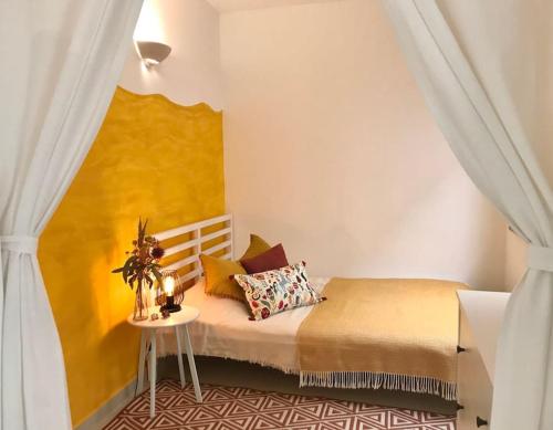 1 dormitorio con 1 cama con pared amarilla en Casa Saudade - FERRAGUDO CENTRE, en Ferragudo