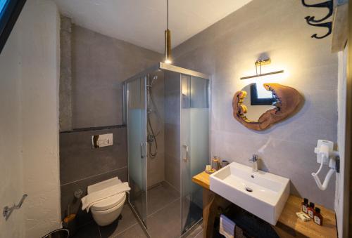 a bathroom with a toilet and a shower and a sink at Kikonia Art & Suites in Akyaka