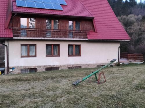 a house with a red roof with a green pole at Chata Pod Kwiatkiem in Zawoja