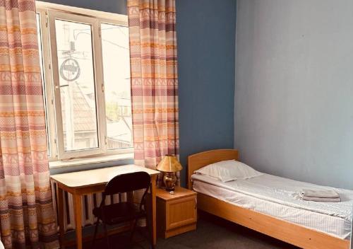 a small bedroom with a bed and a window at Guest House Crocus in Bishkek
