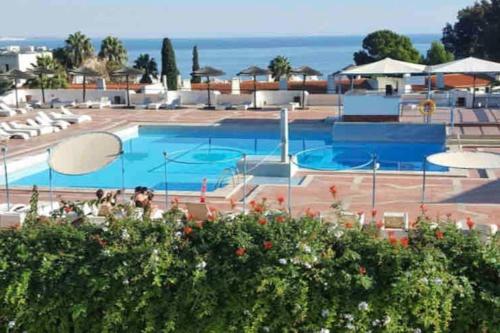 a large swimming pool with chairs and umbrellas at ELdorado JArdim open view beach 5 minutes foot in Albufeira