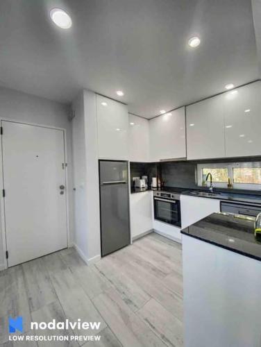 a large kitchen with white cabinets and appliances at ELdorado JArdim open view beach 5 minutes foot in Albufeira