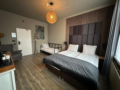 1 dormitorio con 1 cama grande y 1 sofá en Hotel Buren en West-Terschelling