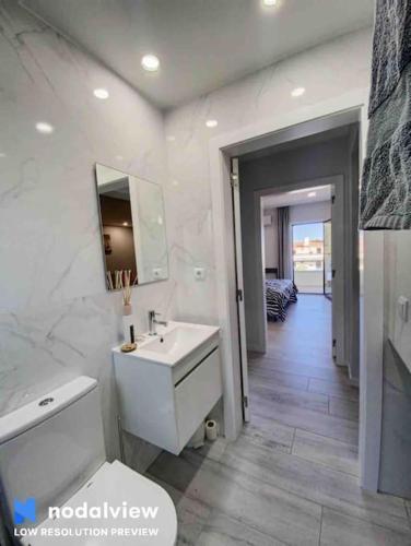 a white bathroom with a sink and a mirror at ELdorado JArdim open view beach 5 minutes foot in Albufeira