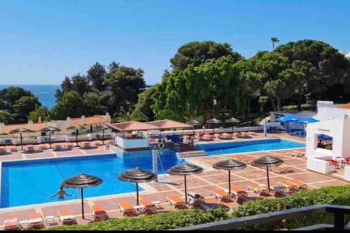 a resort with a pool and chairs and umbrellas at ELdorado JArdim open view beach 5 minutes foot in Albufeira