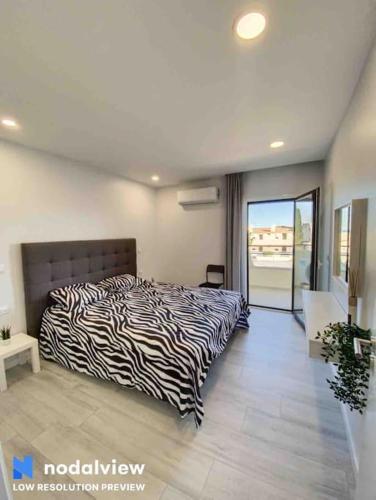 a bedroom with a zebra print bed and a balcony at ELdorado JArdim open view beach 5 minutes foot in Albufeira