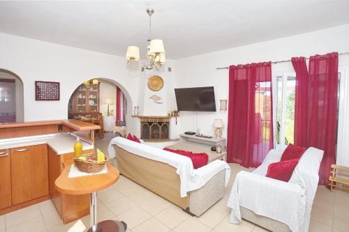 a living room with two couches and a tv at Eleni's House by Corfuescapes in Corfu