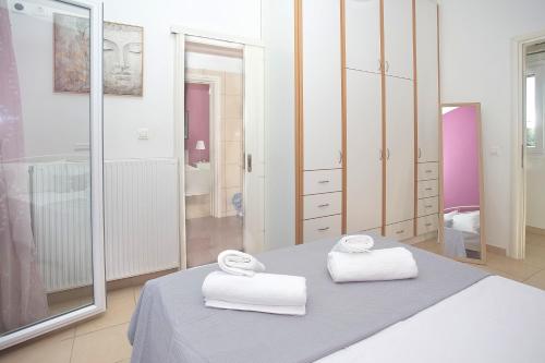 a bedroom with two towels sitting on a bed at Eleni's House by Corfuescapes in Corfu