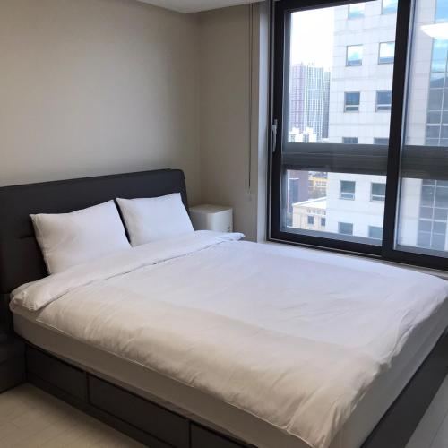 a bed in a room with a large window at Tempus urban stay hotel in Daegu