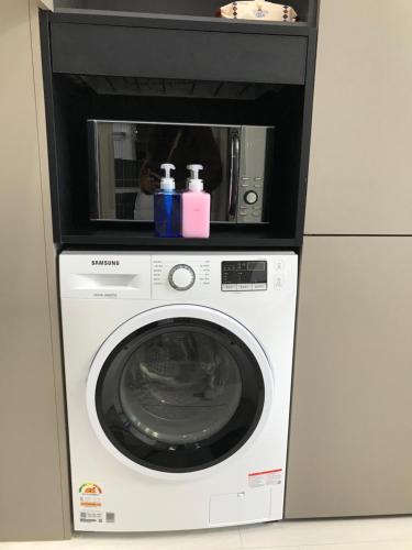 a washing machine with a microwave on top of it at Tempus urban stay hotel in Daegu