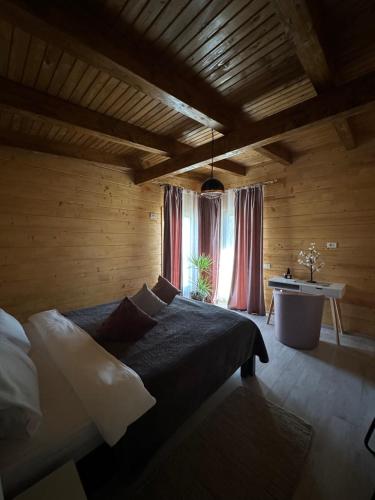 a bedroom with a bed and a desk and a window at Mon Resort by Ana1St in Scărişoara