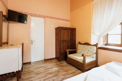 ポルタリアにあるArchontiko Kantartziのベッドルーム1室(ベッド1台、椅子、窓付)