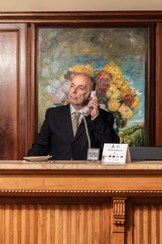 a man in a suit talking on a cell phone at Relais La Fattoria in Castel Rigone