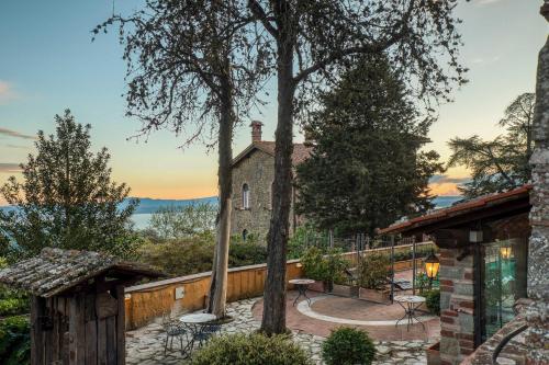 an exterior view of a house with trees and a patio at Relais La Fattoria in Castel Rigone