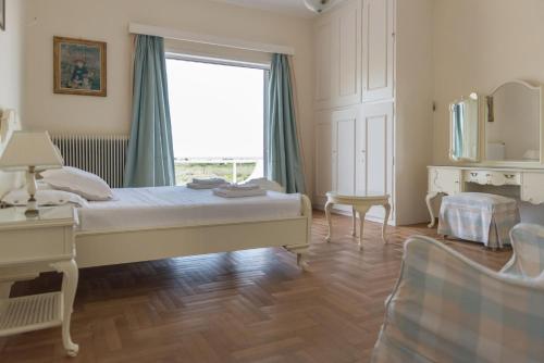 - une chambre avec un lit et une grande fenêtre dans l'établissement Pelion's Finest Estate, à Káto Lekhónia