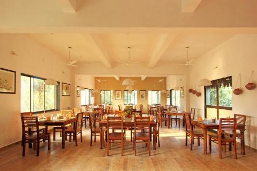 a dining room with wooden tables and chairs at Gir Birding Lodge in Sasan Gir