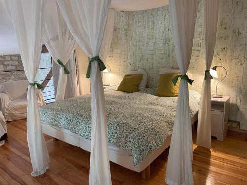 1 dormitorio con 1 cama con cortinas blancas en Puechblanc Gîtes et Chambre d'hôte dans le Triangle d'or Gaillac-Albi-Cordes sur Ciel en Fayssac