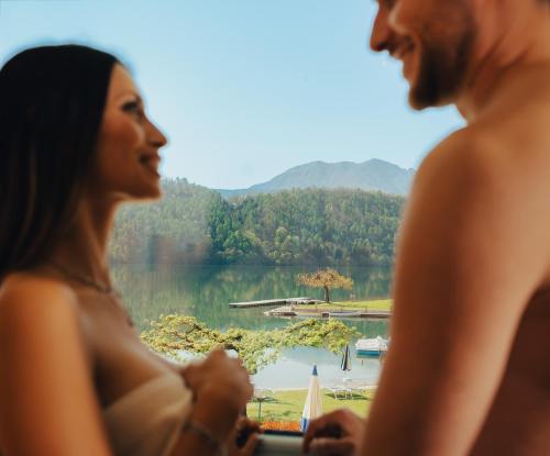 two women looking out a window at a lake at Parc Hotel Du Lac in Levico Terme
