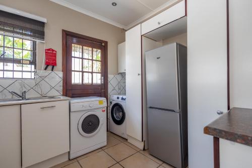 a kitchen with a refrigerator and a washer and dryer at Zuri Place in East London
