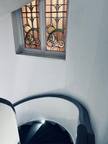 a window in a white wall with a stairway at Hotel Abberdeen in Brussels