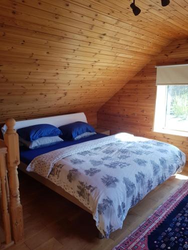 a bedroom with a bed in a log cabin at Čapuliši in Kandava