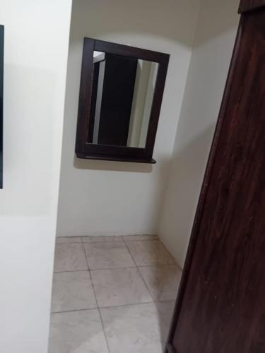Cette chambre est dotée d'un miroir sur un mur blanc. dans l'établissement الفاخرة, à Khobar