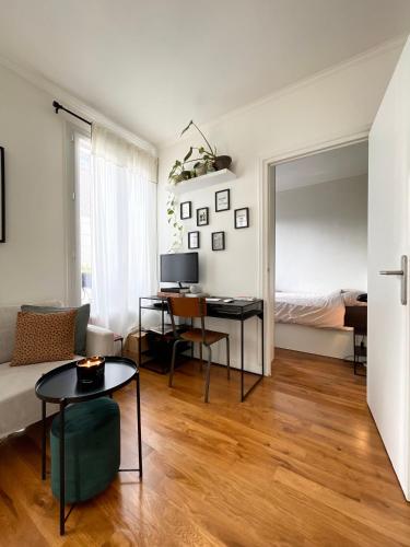 - un salon avec un lit et un bureau dans l'établissement Charmant 2 pièces lumineux proche métro L14 Clichy proche Paris, à Clichy