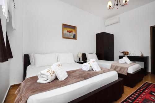 two beds in a room with towels on them at Villa ELMAR in Berat