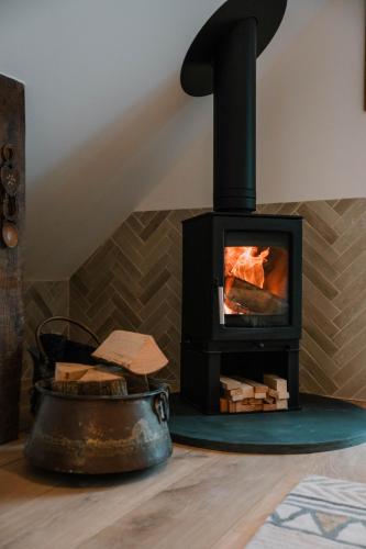a wood stove with a fire in a room at Hafan in Glasbury