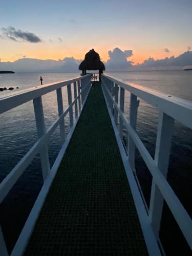 a bridge over the ocean with a person walking on the beach at Vacay Vibes-2 Pools, Pickleball, Coffee Bar, 2 Jacuzzis, Food Truck in Key Largo