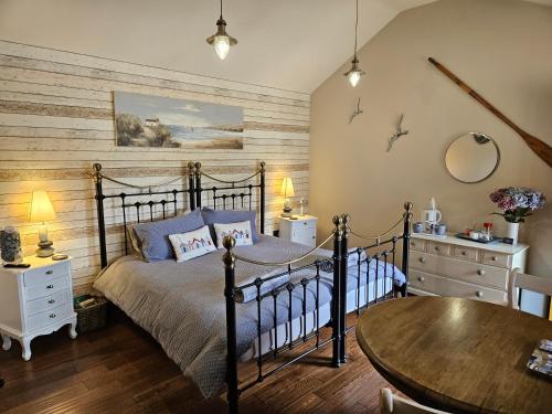 a bedroom with a bed and a wooden wall at Lyonshall Lodge in Kington