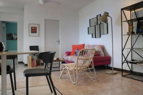 a living room with a red couch and chairs at 34 ° soley. in Case-Pilote