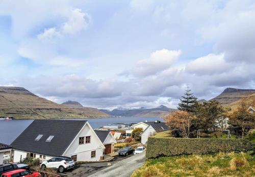 a view of a village with a lake and mountains at Cozy apartment in Runavík in Saltangará