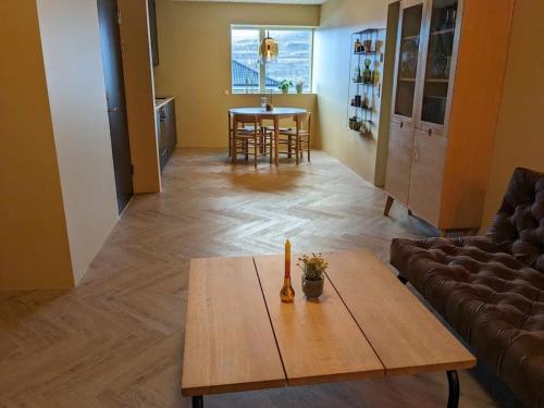 een woonkamer met een tafel en een bank bij Cozy apartment in Runavík in Saltangará