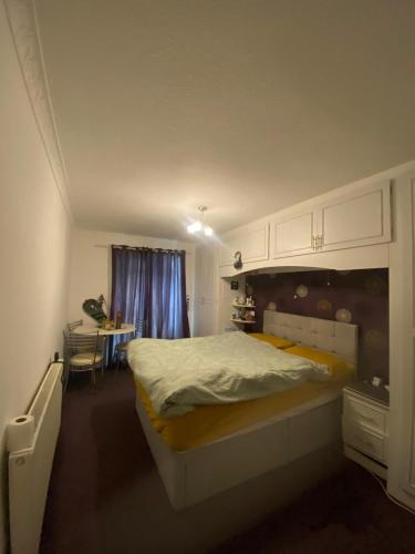 een slaapkamer met een groot bed en een tafel bij Quiet flat with a private spacious room in Birmingham