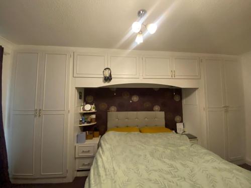 a bedroom with a bed and white cabinets at Quiet flat with a private spacious room in Birmingham