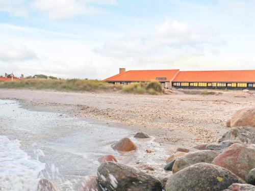 un edificio en una playa con rocas delante en 6 person holiday home on a holiday park in S by en Sæby