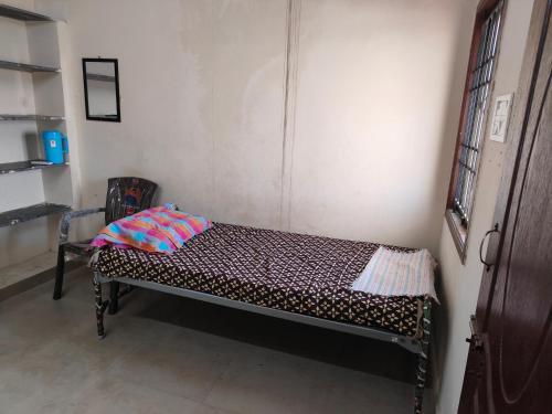 uma pequena cama num canto de um quarto em AGP Castle em Chennai