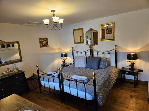 a bedroom with a bed and two lamps and a mirror at Lyonshall Lodge in Kington