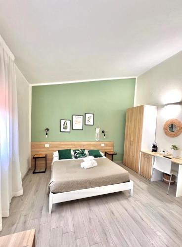 a bedroom with a bed and a green wall at InCentro - San Teodoro in San Teodoro