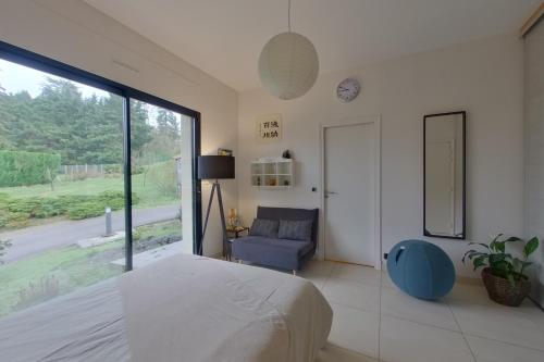 ein Schlafzimmer mit einem Bett, einem Stuhl und einem Fenster in der Unterkunft Villa Serenity in Chambourcy
