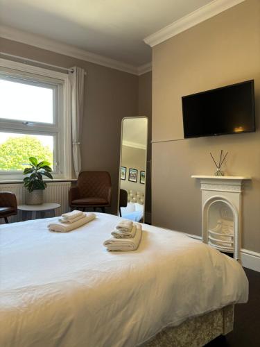 a bedroom with a large bed with a fireplace at Large North Facing Room above G Grace & Son in Tring