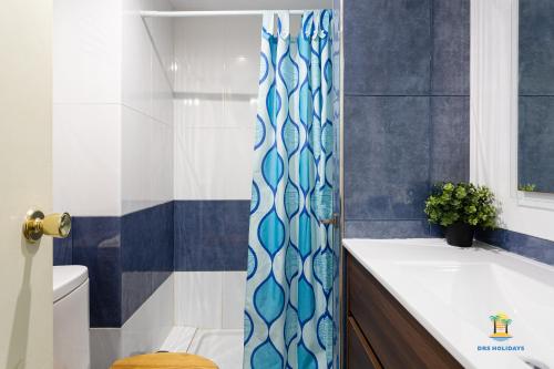 een badkamer met een blauw en wit douchegordijn bij Da Paolo Apartment (in front of the beach) in Lloret de Mar